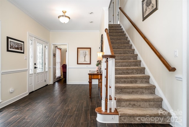 foyer entrance with stairway, baseboards, ornamental molding, and dark wood-style flooring