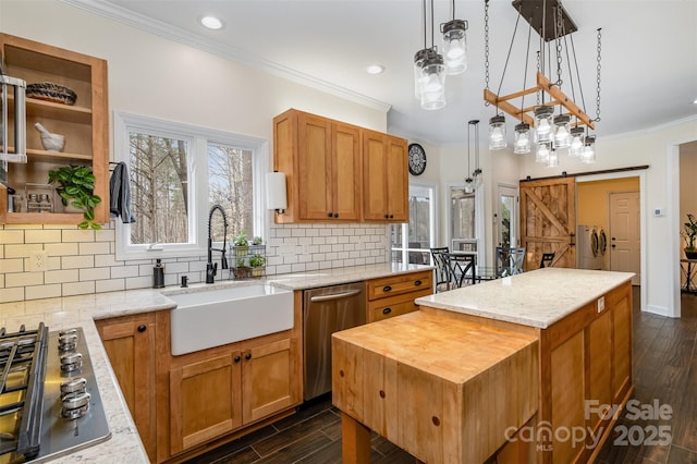 kitchen with a sink, appliances with stainless steel finishes, dark wood finished floors, and a center island