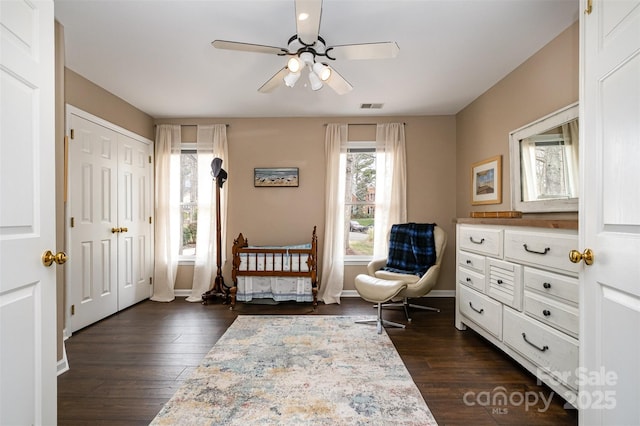 sitting room with dark wood finished floors, visible vents, baseboards, and ceiling fan