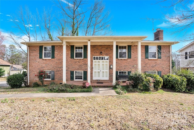 split foyer home with brick siding and a chimney