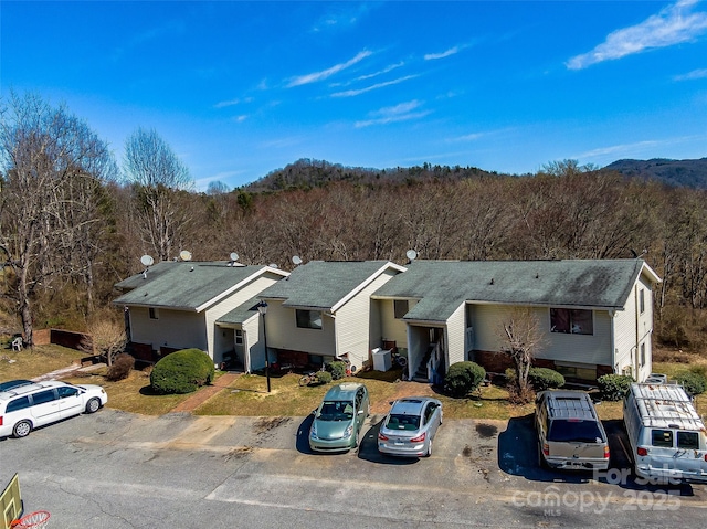 view of front of property featuring a view of trees