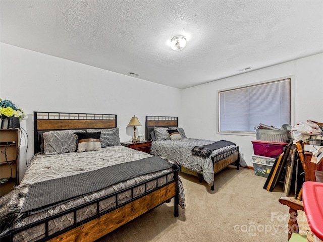 carpeted bedroom with visible vents and a textured ceiling