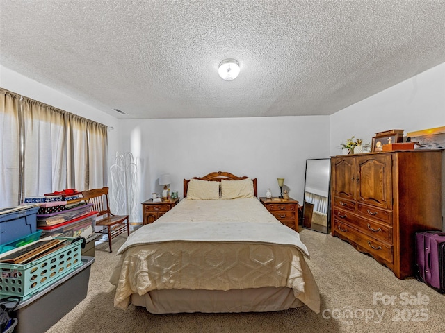 bedroom featuring a textured ceiling, carpet floors, and visible vents