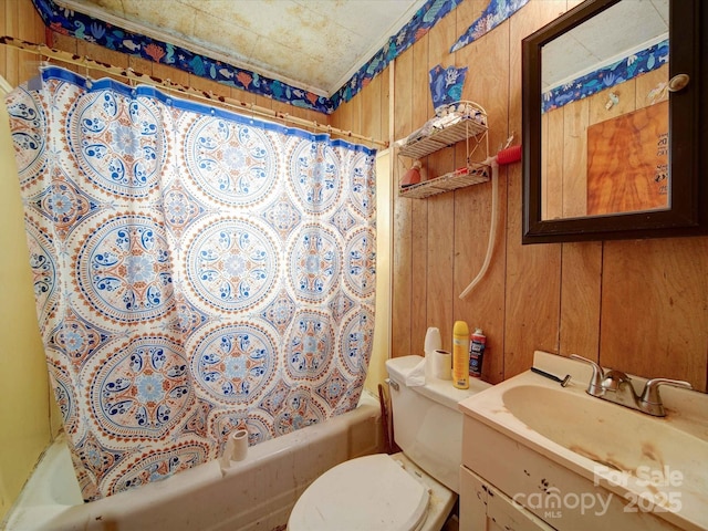 full bathroom with toilet, wood walls, shower / tub combo with curtain, and vanity