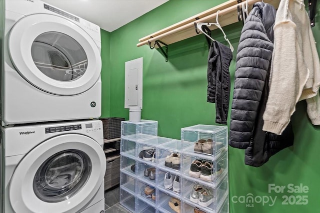 laundry room featuring stacked washer and clothes dryer, electric panel, and laundry area