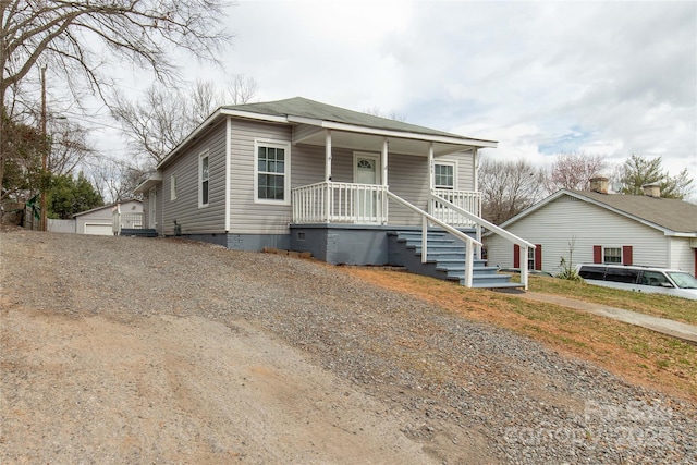 bungalow featuring a porch, crawl space, and an outdoor structure