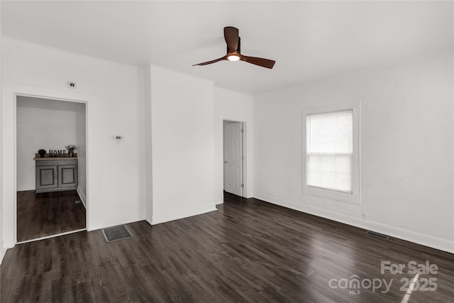 interior space featuring dark wood-style floors, visible vents, and baseboards