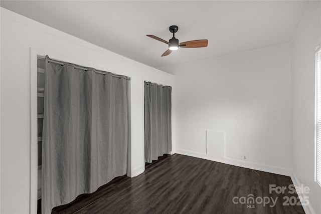 unfurnished room with ceiling fan, dark wood-style flooring, and baseboards