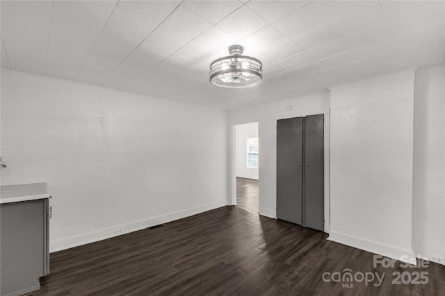 interior space with baseboards and dark wood-type flooring