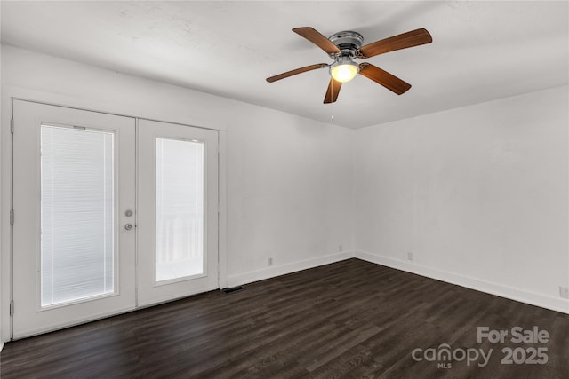 spare room featuring dark wood-type flooring, french doors, visible vents, and baseboards