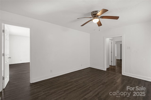 empty room featuring dark wood finished floors, baseboards, and ceiling fan