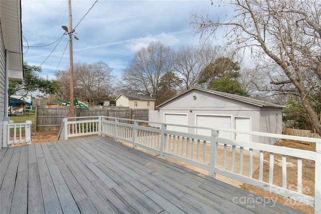 deck with an outbuilding, a detached garage, and fence