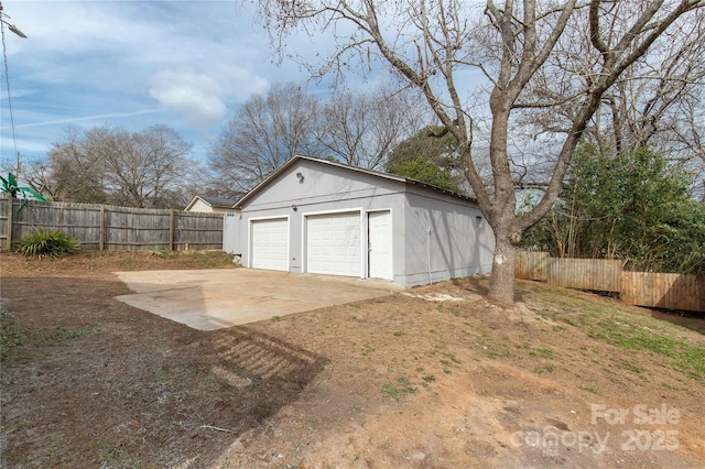 detached garage featuring fence