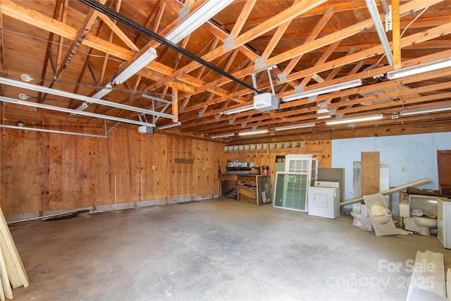 garage with washer / clothes dryer and a garage door opener