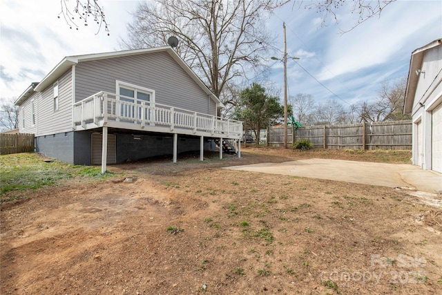 back of property with stairway, fence, a deck, and a patio