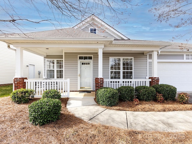 view of front of house with a porch, an attached garage, and brick siding