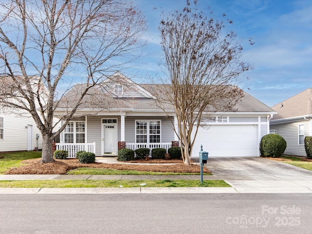 view of front of house with a garage, driveway, and a porch