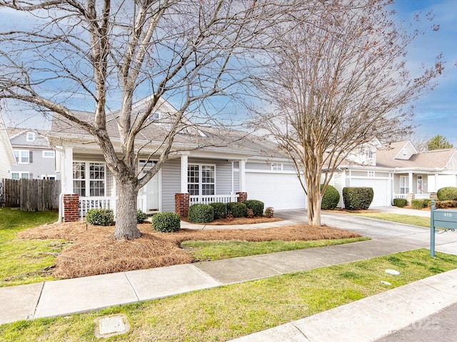 view of front of property featuring driveway, fence, and a porch