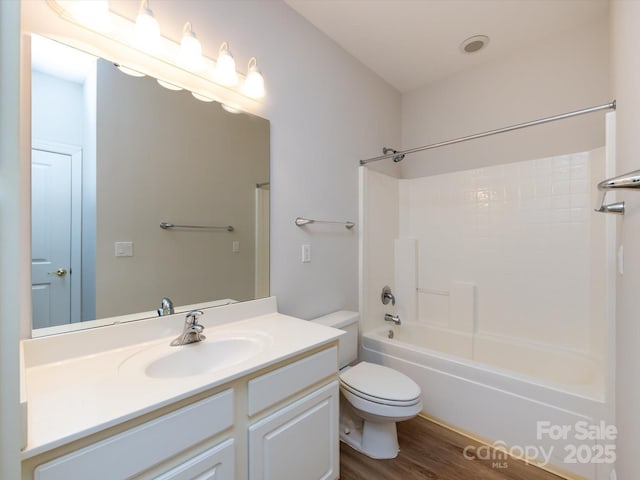 bathroom featuring bathing tub / shower combination, vanity, toilet, and wood finished floors