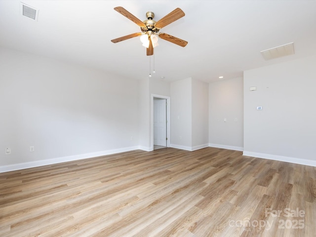 spare room featuring a ceiling fan, light wood-type flooring, visible vents, and baseboards