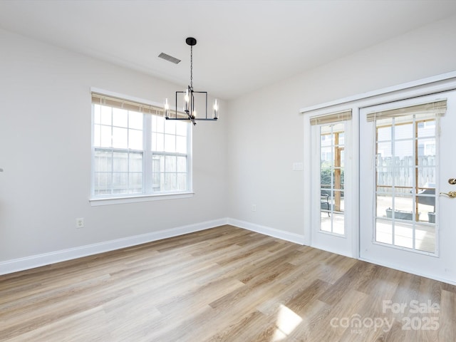 unfurnished dining area featuring light wood-type flooring, plenty of natural light, visible vents, and baseboards