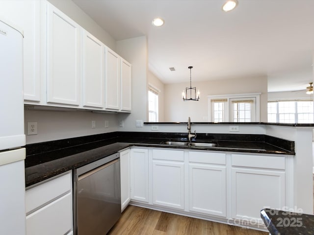 kitchen with freestanding refrigerator, a healthy amount of sunlight, a sink, and stainless steel dishwasher