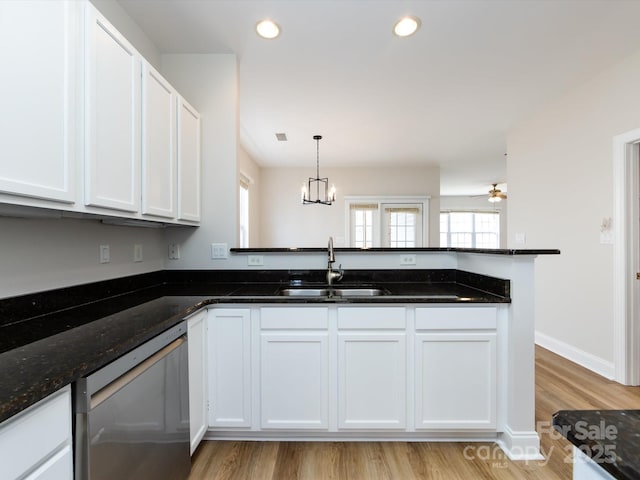 kitchen with white cabinets, a peninsula, stainless steel dishwasher, a sink, and recessed lighting