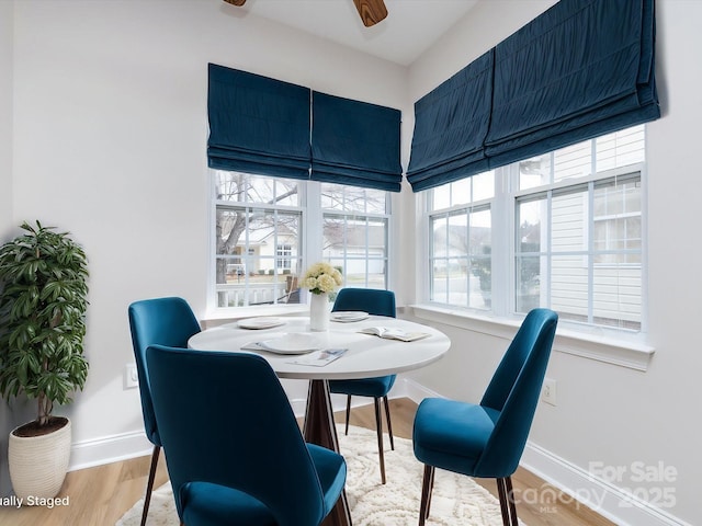 dining area with ceiling fan, baseboards, and wood finished floors