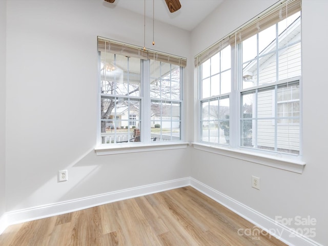 empty room with ceiling fan, baseboards, and wood finished floors