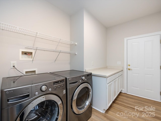 clothes washing area with separate washer and dryer, cabinet space, and light wood-style floors