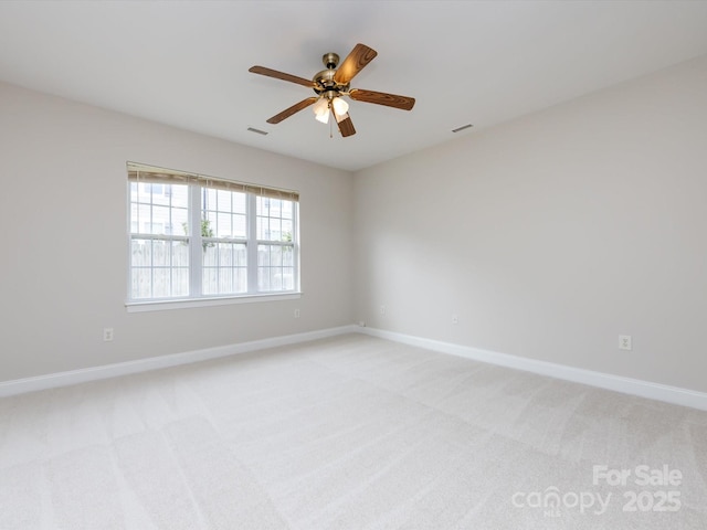 empty room featuring visible vents, baseboards, and light colored carpet