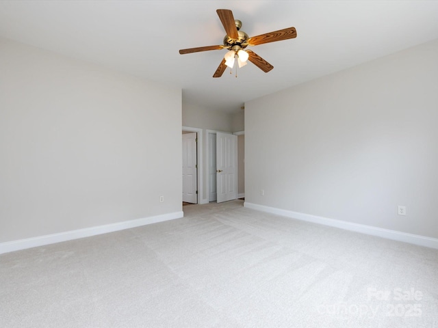 unfurnished room with ceiling fan, light colored carpet, and baseboards