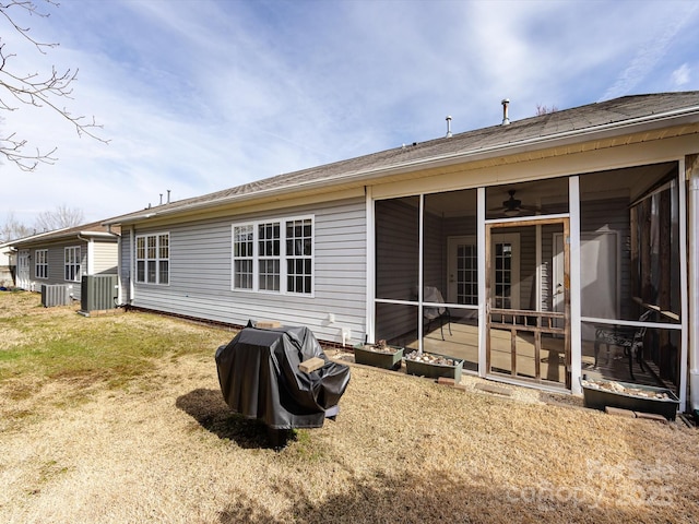 rear view of property with a sunroom and central AC