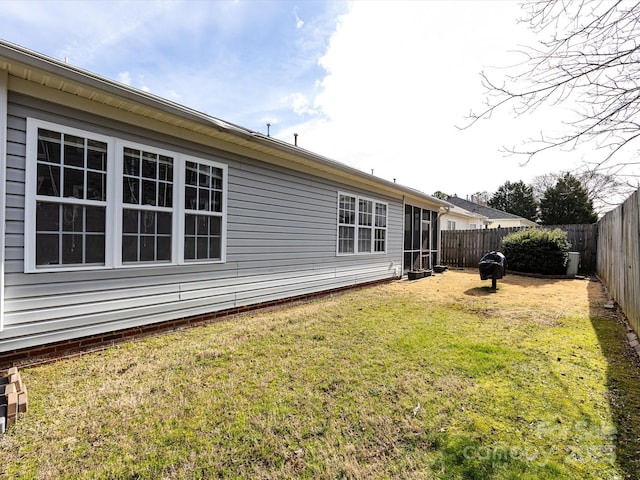 back of property with a fenced backyard and a lawn