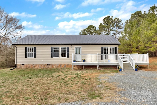 back of property featuring metal roof, crawl space, a wooden deck, and a lawn