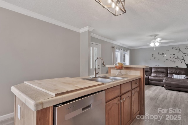 kitchen featuring dishwasher, open floor plan, crown molding, light wood-type flooring, and a sink