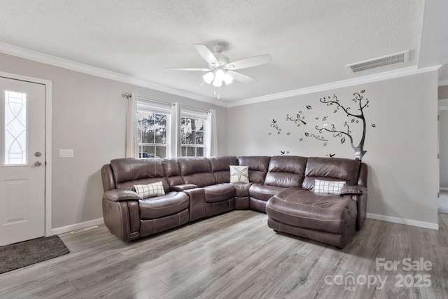 living area with light wood-type flooring, visible vents, and a textured ceiling