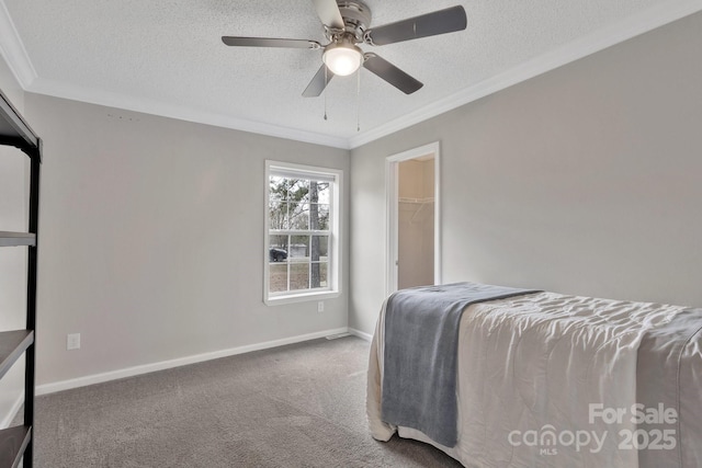 bedroom with carpet flooring, crown molding, a textured ceiling, and baseboards