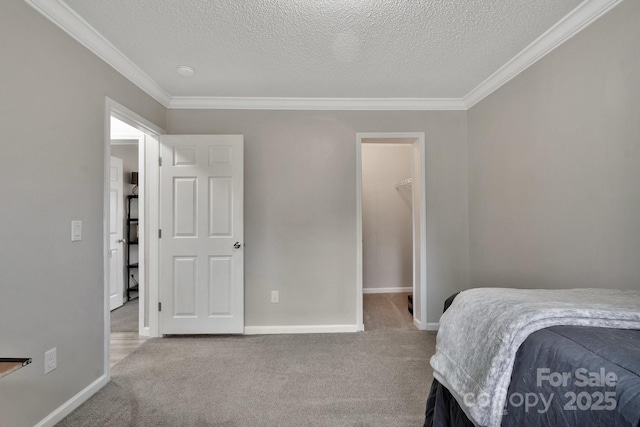 bedroom featuring ornamental molding, carpet flooring, a textured ceiling, and baseboards