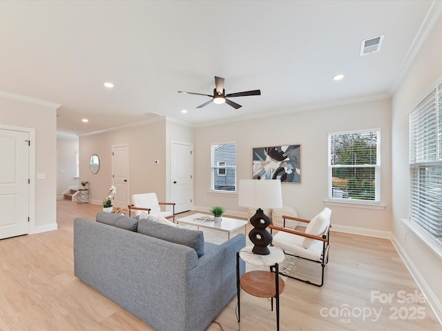 living area with ceiling fan, visible vents, ornamental molding, and light wood finished floors
