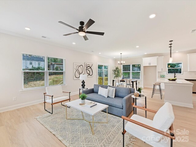 living area with visible vents, baseboards, ceiling fan with notable chandelier, recessed lighting, and light wood-style flooring