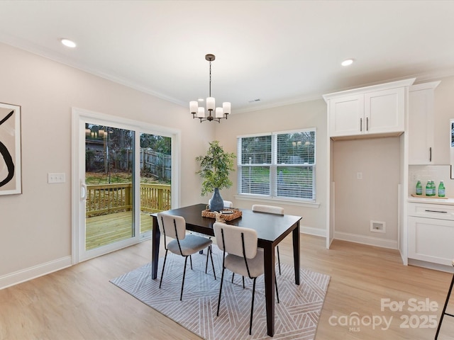 dining room with crown molding, baseboards, light wood-type flooring, recessed lighting, and a notable chandelier