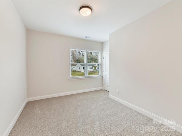 unfurnished room with baseboards, visible vents, and carpet