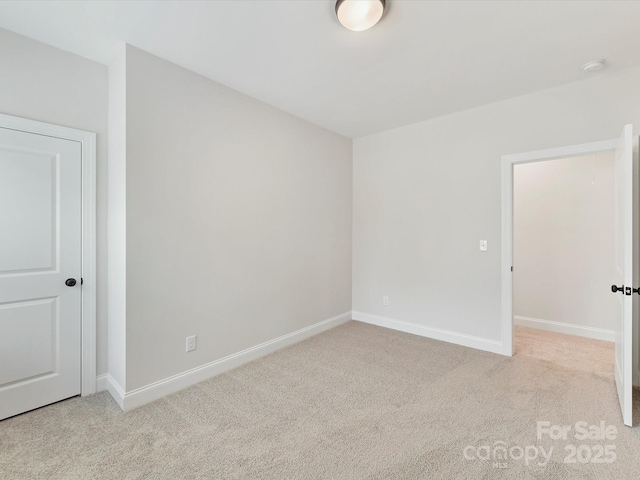 carpeted spare room with baseboards