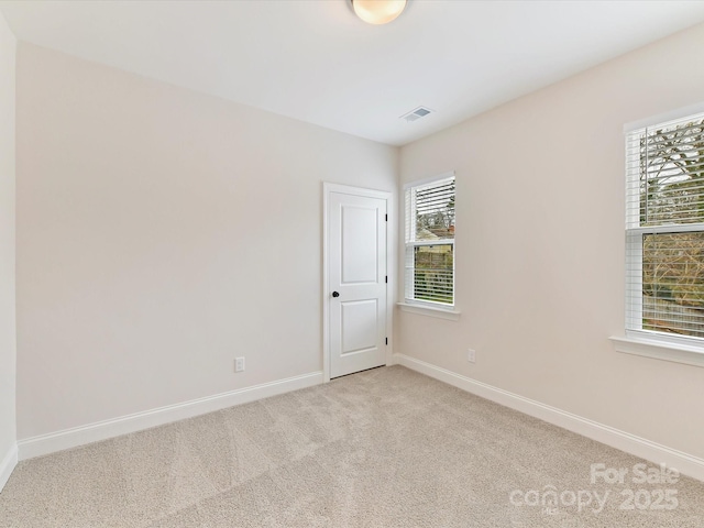 carpeted spare room with baseboards and visible vents