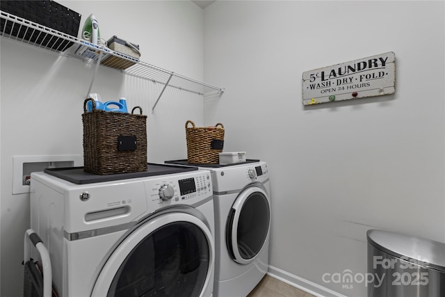 clothes washing area featuring laundry area, washing machine and dryer, and light tile patterned floors