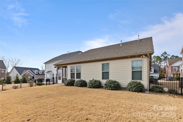 back of property with a shingled roof, a residential view, fence, and a lawn