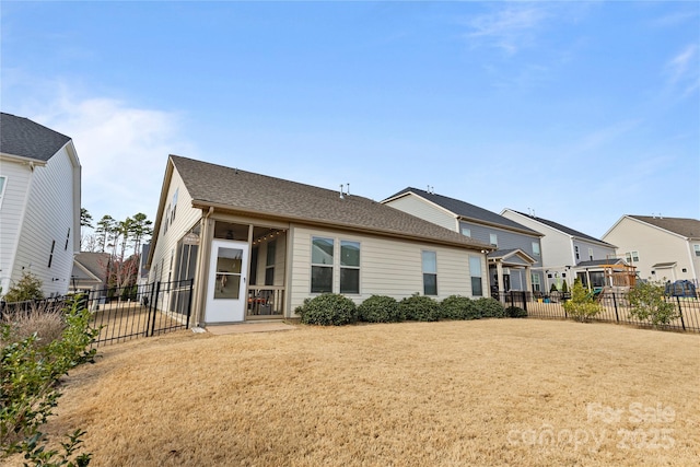 rear view of house featuring fence and a yard