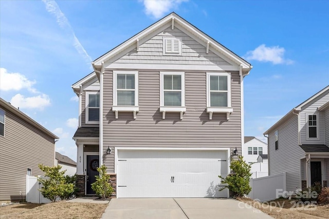 view of front facade with a garage, concrete driveway, and fence