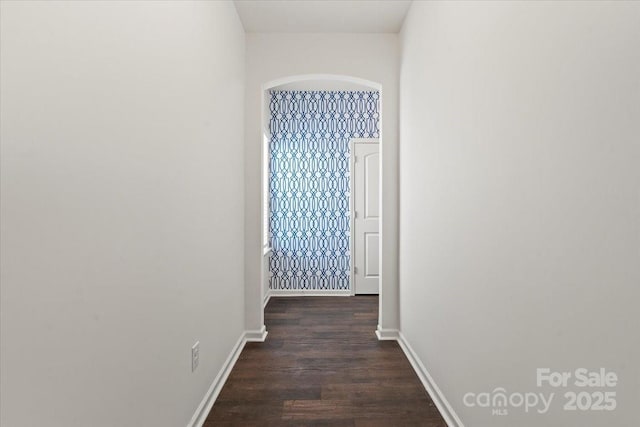 hall featuring dark wood-type flooring and baseboards